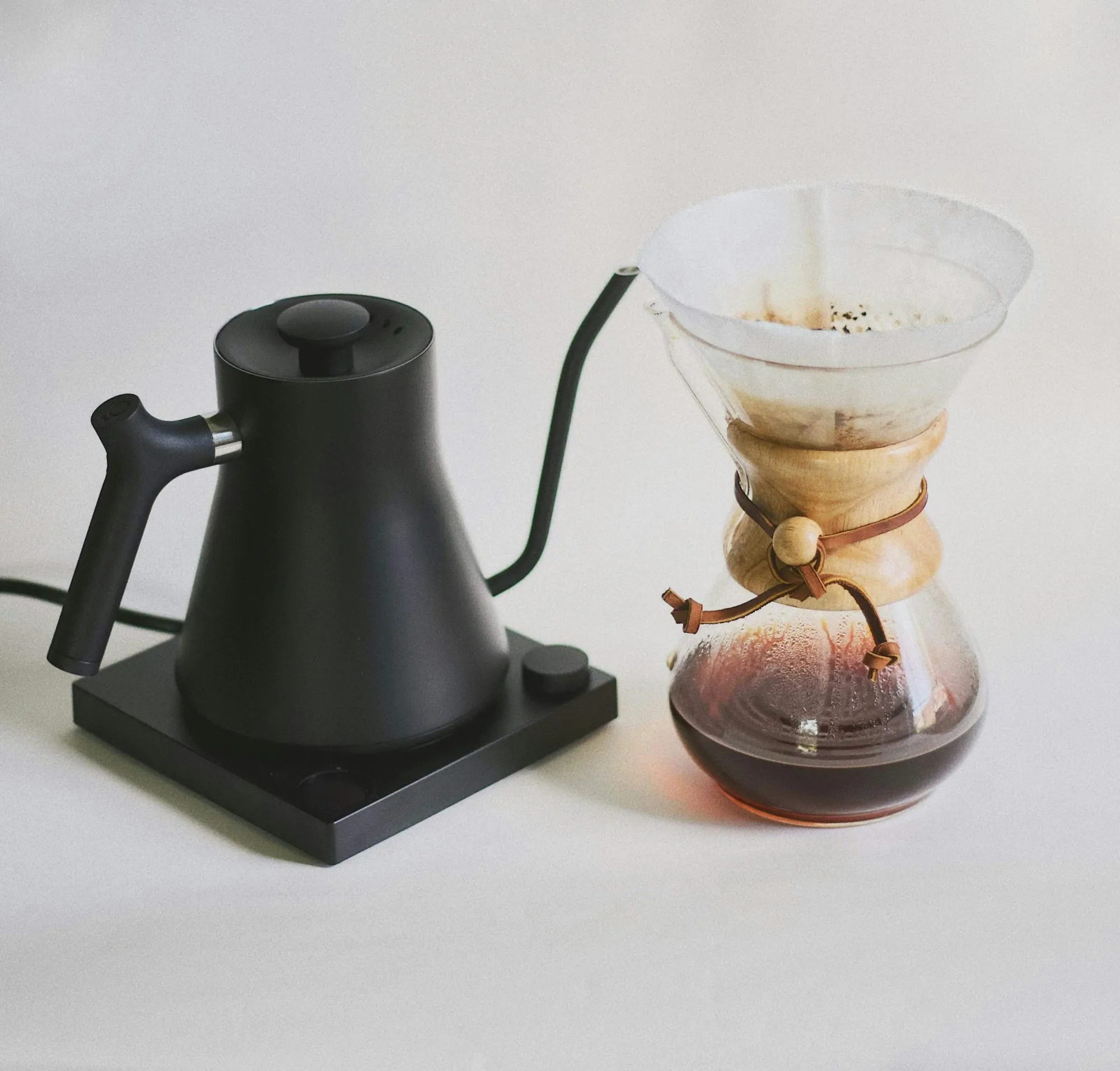 fellow stagg ekg electric kettle in black next to a chemex brew